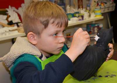 boy painting batman plaster figurine