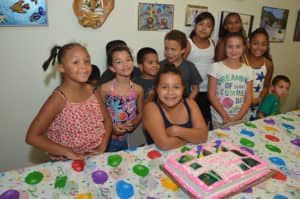 kids around cake at birthday party