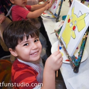 Boy painting a pokemon during a birthday party