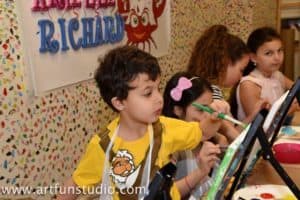 Boy painting during canvas painting birthday