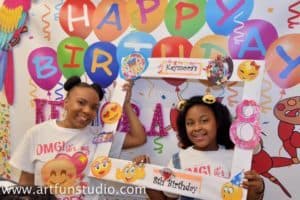 Girls pose in picture frame during a birthday party