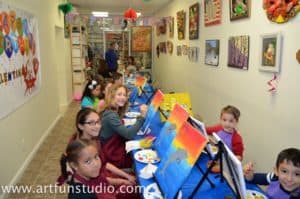 Kids paint on canvas during a birthday party