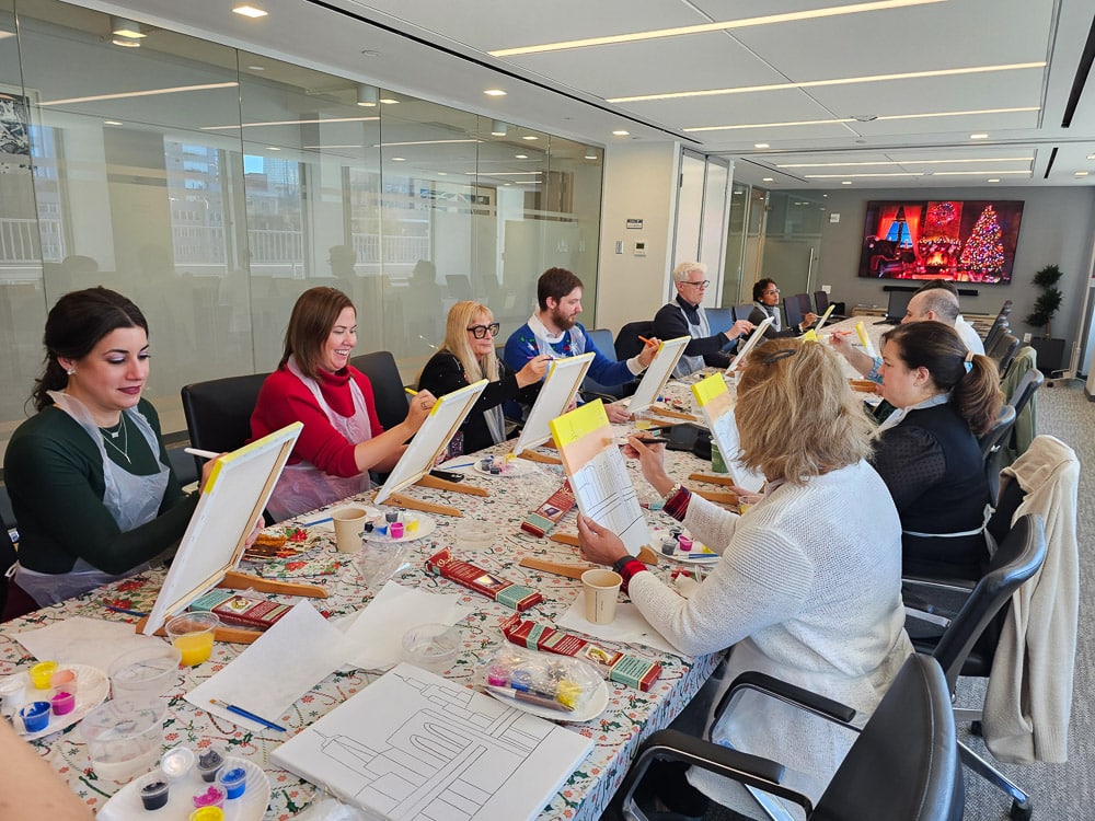 People painting during our on-site sip and paint holiday event in New York city