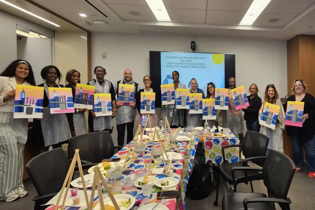 Law firm employees holding their pictures after Sip and Paint event