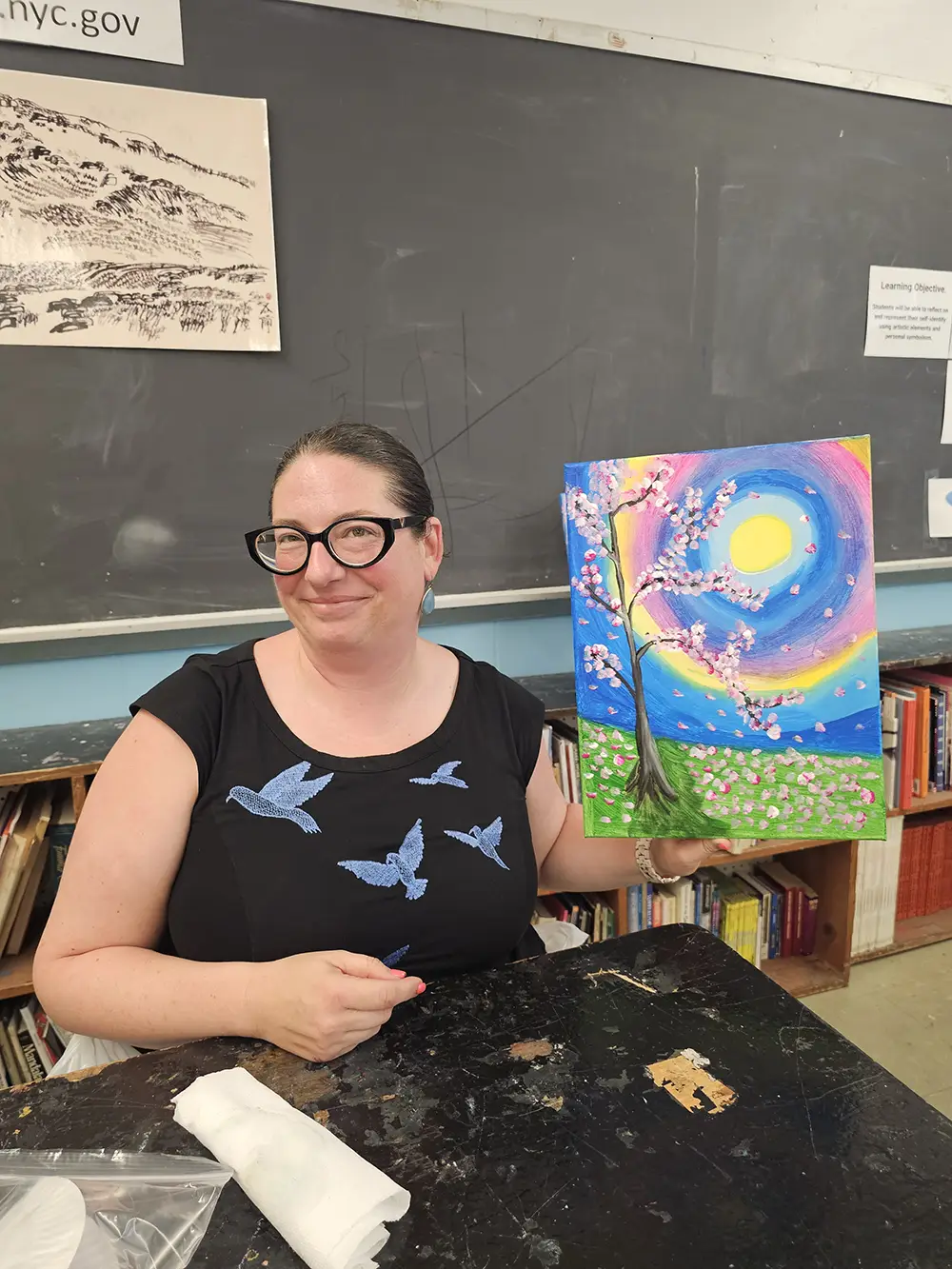 A teacher holding her artwork