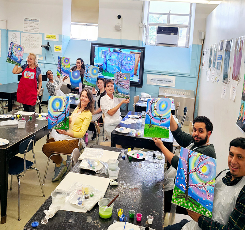 teachers holding painting during art workshop