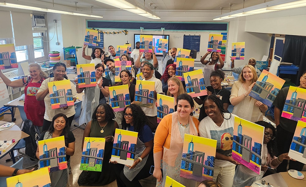 Teachers holding painting during PD day